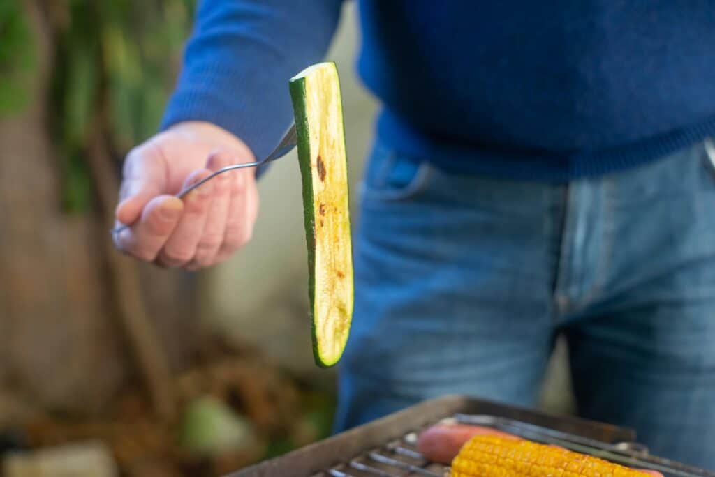 pexels-kampus-homme retournant un légume au barbecue-7 accompagnements à cuisiner pour un barbecue