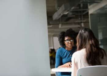pexels-divinetechygirl-jeune diplomée qui passe un entretien d'embauche avec une femme devant elle-Comment se passent les premiers entretiens d'embauche des jeunes diplômés ?