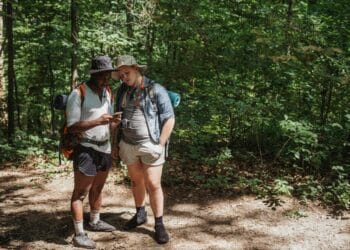 pexels-kamaji-ogino-étudiant en randonnée regardant une carte-Pourquoi partir en randonnée avec tes potes pour les vacances ?