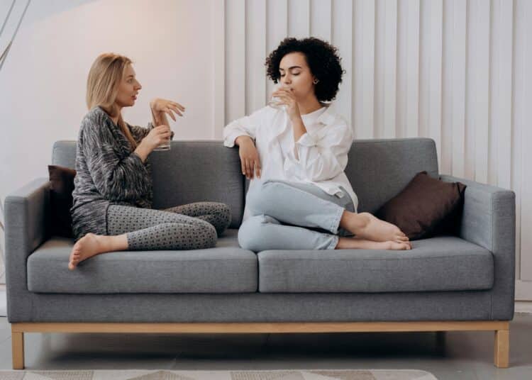 pexels-mikhail-nilov-deux étudiantes assises sur un canapé et qui discutent-6 façons de créer du lien avec ses nouveaux colocs