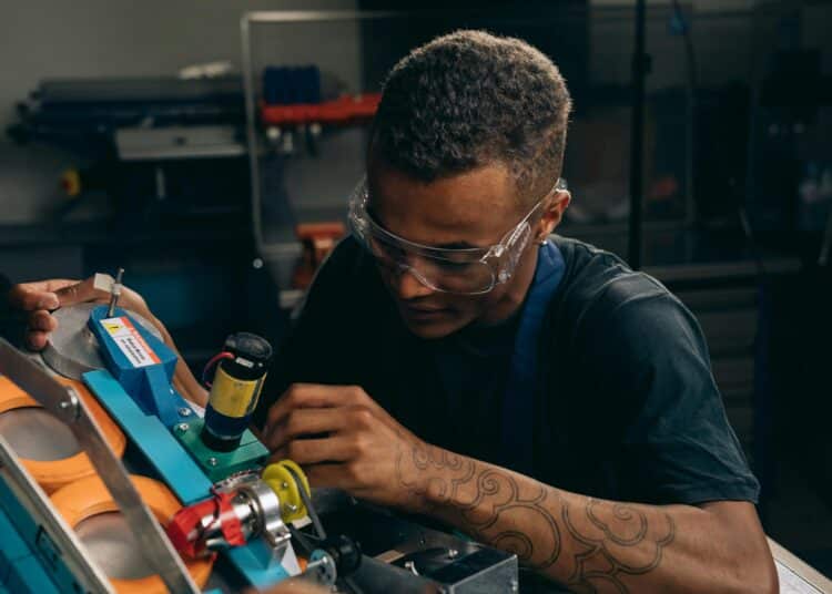 pexels-mikhail-nilov-jeune travailleur sur une machine qu'il répare-Entrer dans le monde du travail qu’est-ce qui change dans ma vie ?