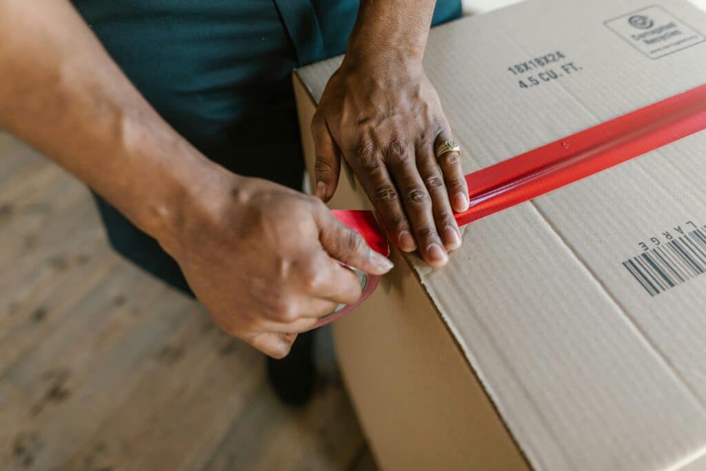 pexels-rdne-personne qui ferme un carton de déménagelent-10 indispensables à avoir dans son kot pour un premier aménagement