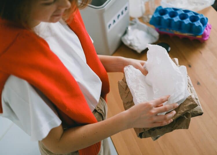 pexels-shvets-production-jeune étudiante qui trie des déchèts dans son kot-8 gestes pour l'environnement à adopter au kot