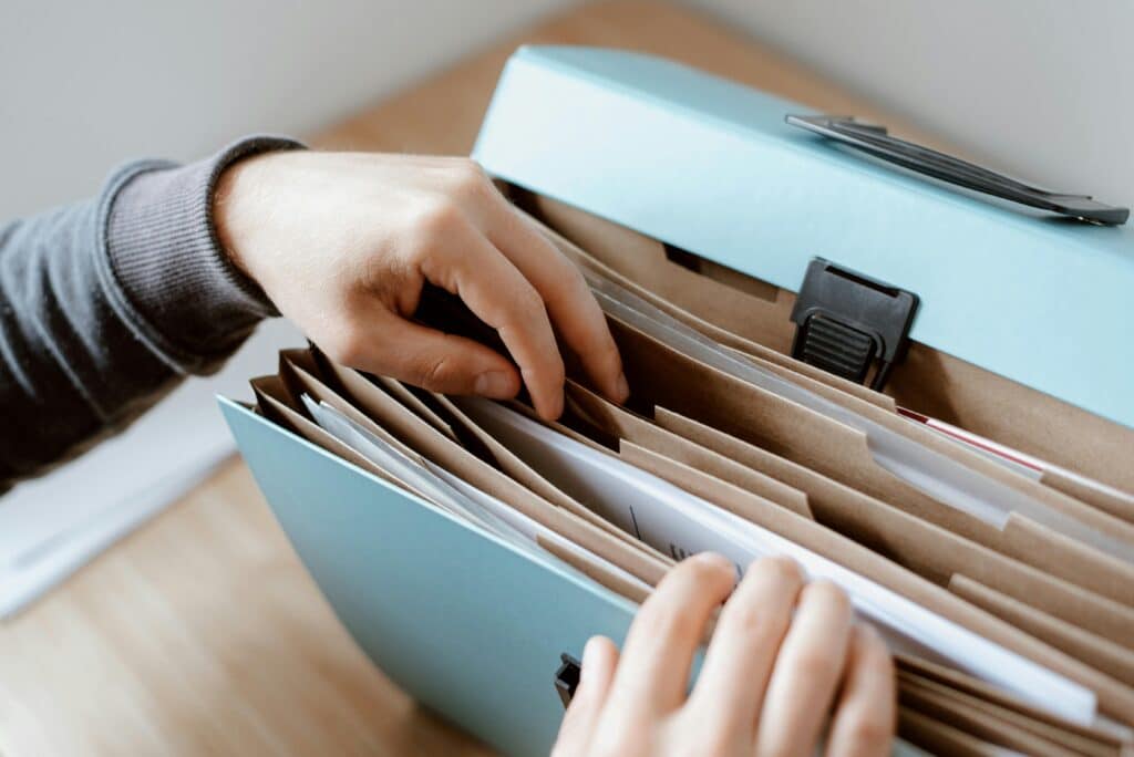 pexels-anete-lusina-étudiant qui fouille un classeur rempli de documents-Études comment s'organiser pour recevoir des aides financières ?