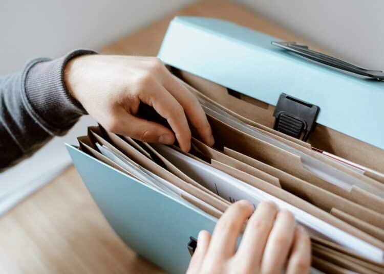 pexels-anete-lusina-étudiant qui fouille un classeur rempli de documents-Études comment s'organiser pour recevoir des aides financières ?