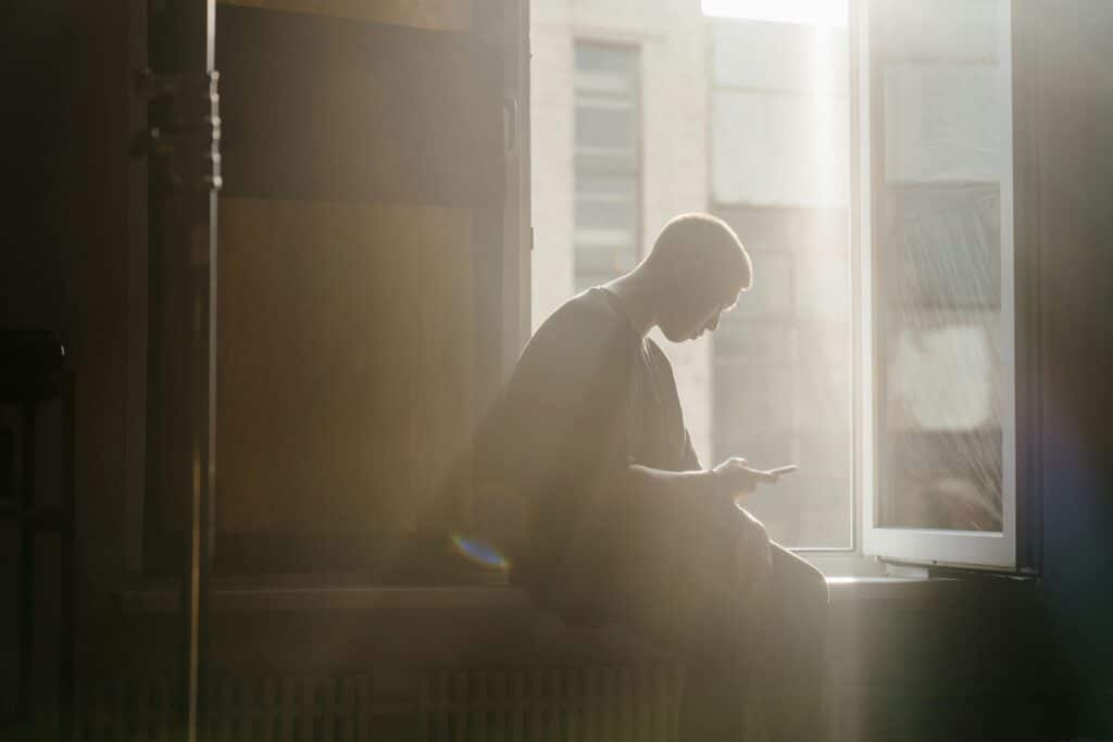 pexels-cottonbro-étudiant à une fenêtre sur son téléphone-7 initiatives sur ton campus pour lutter contre le cyberharcèlement