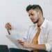 pexels-michael-burrows-jeune étudiant qui lit des feuilles assis sur le divan-7 aides financières que tu ne connaissais pas mais qui pourront t'aider