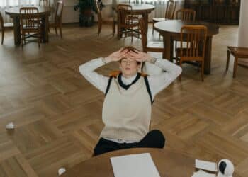 pexels-mikhail-nilov-étudiant en bibliothèque qui se prend la tête dans les mains et qui ne se concentre pas-7 signes que tu as peut-être un trouble du déficit de l'attention
