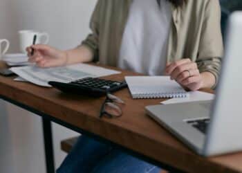 pexels-mikhail-nilov-personne étudiante qui complète des documents sur un bureau-Comment bénéficier de l'allocation d'études en Fédération Wallonie-Bruxelles ?