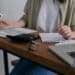pexels-mikhail-nilov-personne étudiante qui complète des documents sur un bureau-Comment bénéficier de l'allocation d'études en Fédération Wallonie-Bruxelles ?